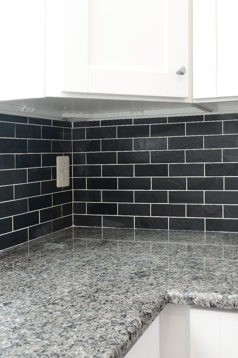 new caledonia granite white cabinet with black subway backsplash tile BA1070