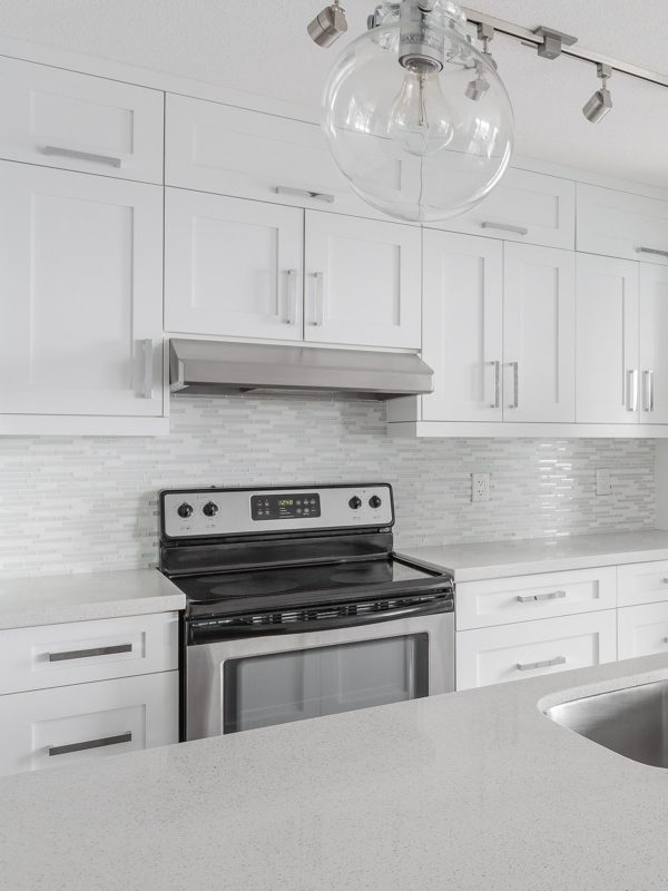 white quartz countertop cabinets with white modern backsplash tile 2