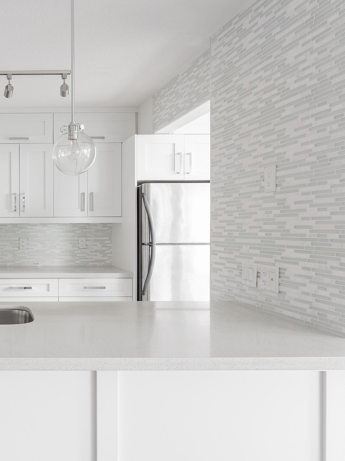 white quartz countertop cabinets with white modern backsplash tile 3