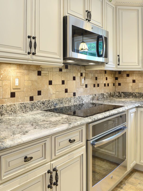 Beige cabinets granite countertop travertine glass backsplash tile BA1043