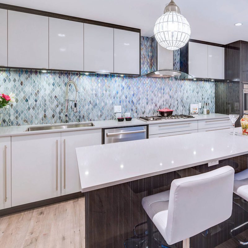 large white quartz island countertop modern cabinets blue backsplash tile