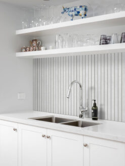 Modern light gray long backsplash tile with white cabinets